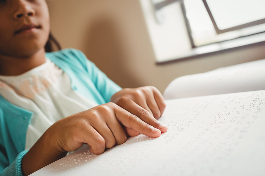 Lapsi lukemassa pistekirjoitustekstiä.